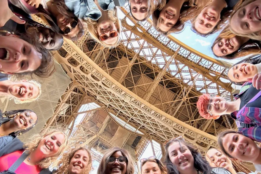 students in a circle under the Eiffel Tower